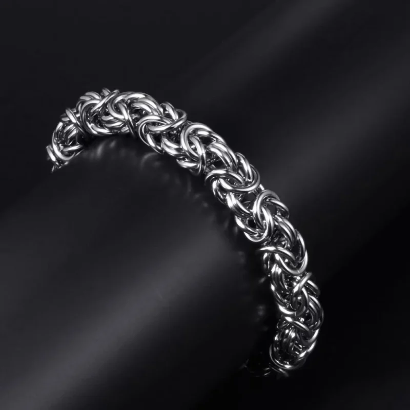 Hand-braided Byzantine chain bracelet made of silver-colored titanium steel on a male wrist.